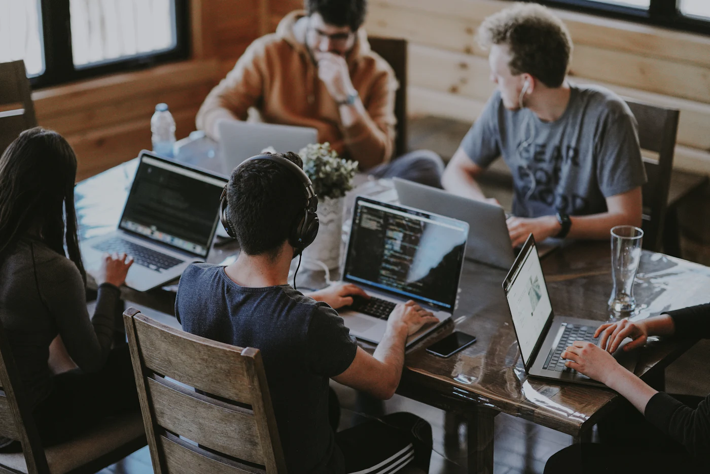 Engineers working on laptops around a shared table